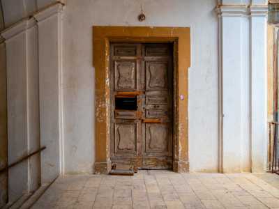Saliamo le rampe di scale fino a una malandata porta in legno che d� accesso al piano nobile